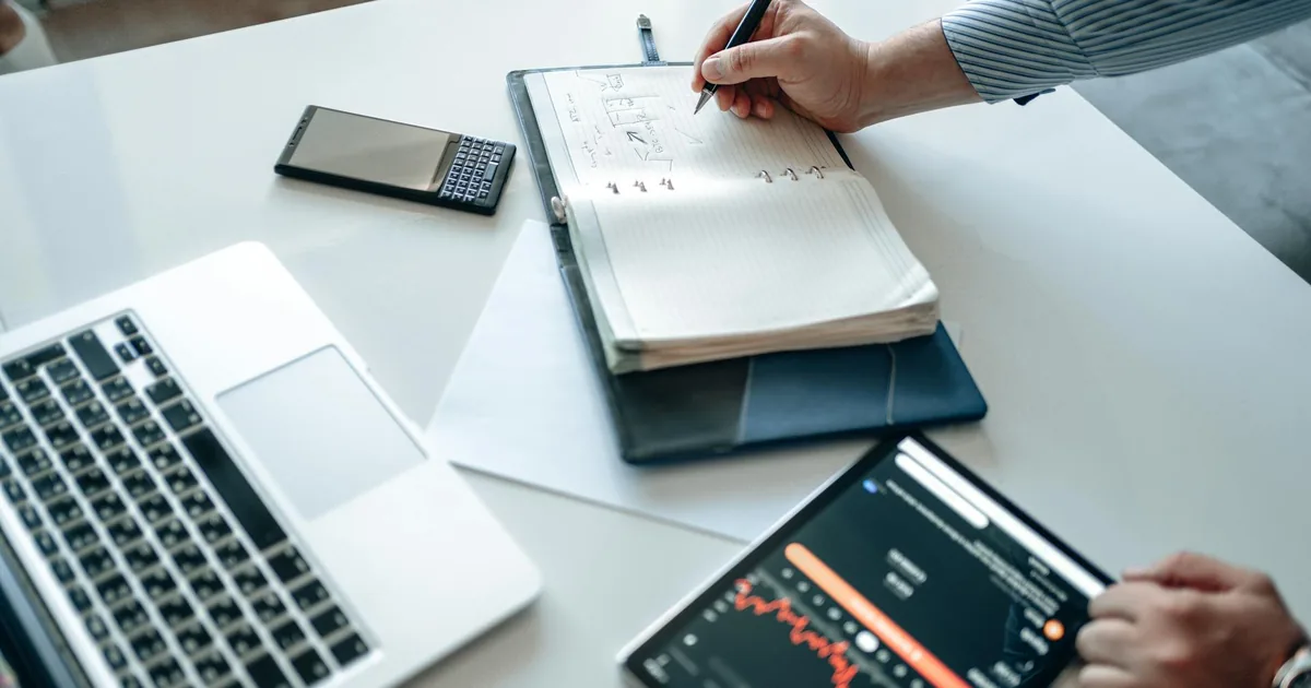 Business owner analyzing financial reports on laptop, tablet, and notebook — Shopify QuickBooks Online integration five document types 2025