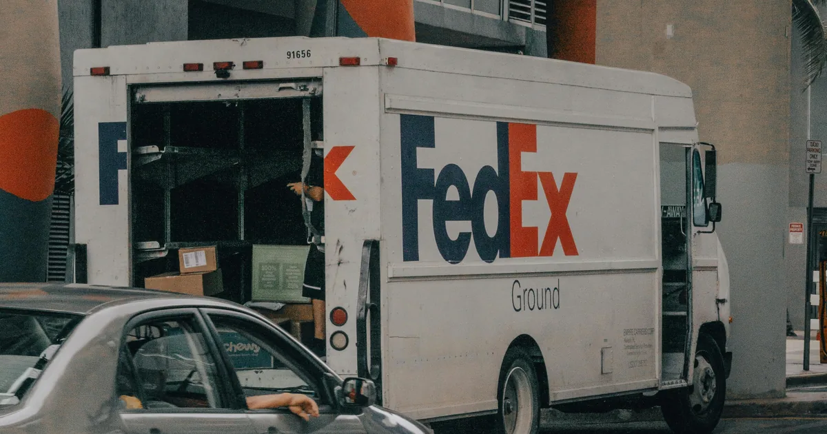 FedEx delivery truck unloading packages on urban city street — Shopify retail delivery fee RDF tracked in QuickBooks Online for Colorado and Minnesota merchants
